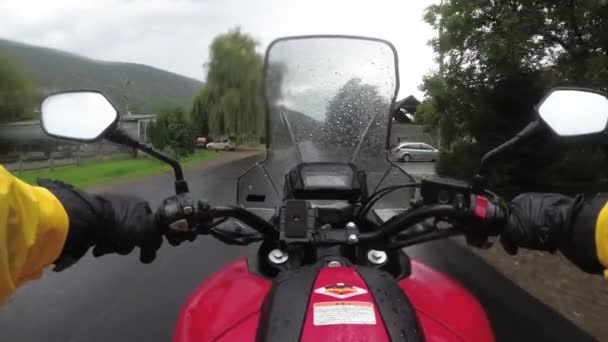 Motociclista en paseos en bicicleta en una carretera de montaña de paisaje bajo la lluvia — Vídeos de Stock