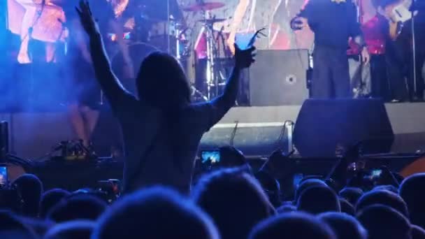군중 속에 모인 여인의 실루엣 - 록 콘서트에서 수화 장치를 보여 주는 여자 — 비디오