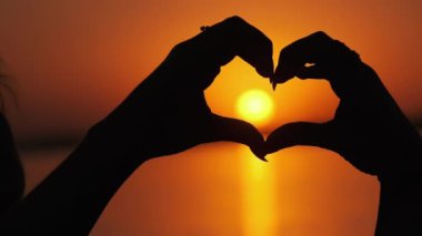 Turuncu Gün Batımında Bir Kalp Şeklinde Kadın Ellerinin Silüeti