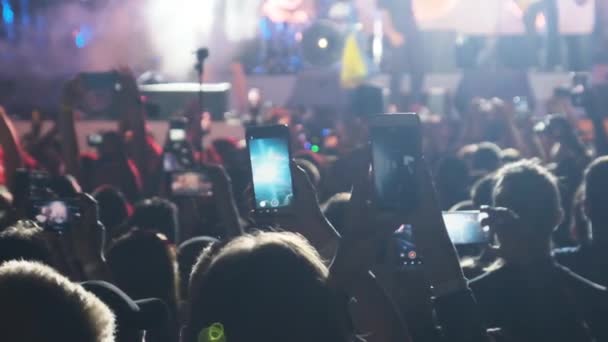 ライブロックコンサートでスマートフォンでビデオを作る群衆のシルエット.スローモーション — ストック動画