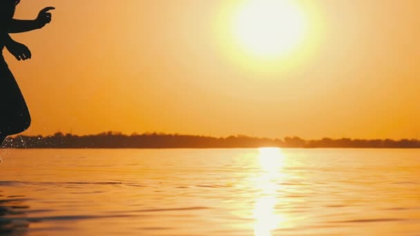 Woman Runs on Shallow Water at Golden Sunset along the Beach (em inglês). Movimento lento 240fps — Vídeo de Stock