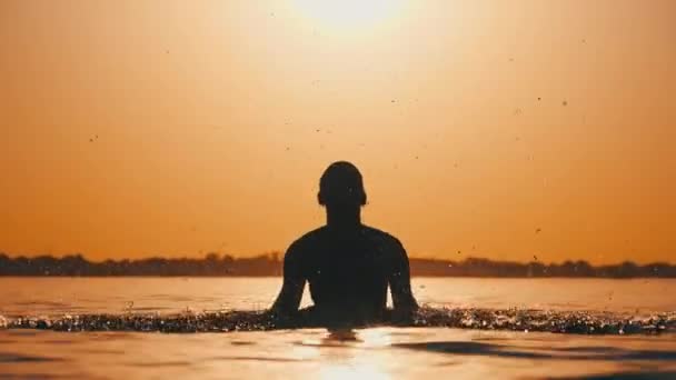 Silhuett av ung lekfull glad kvinna stänk floden vatten vid solnedgången — Stockvideo