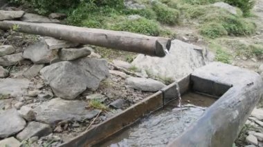 Ahşap borudan düşen kristal berrak taze dağ suyu. Yürüyüş Macerası.