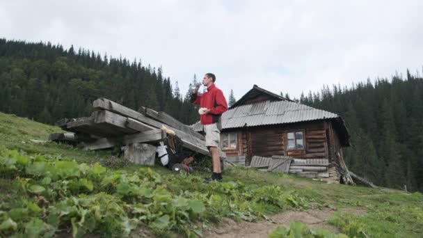 Man toerist met rugzak bij een Halt. Stop in de bergen voor een snack — Stockvideo