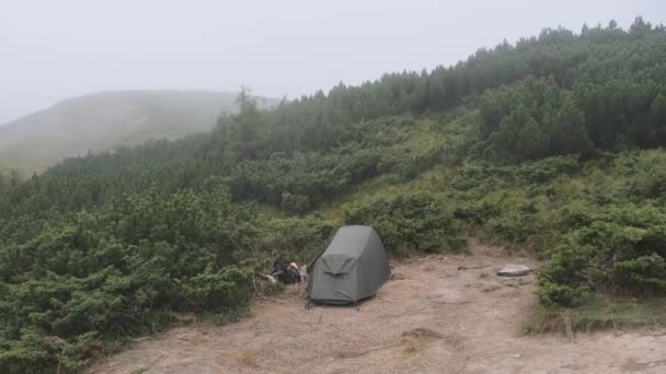 Single Tent is opgezet op een heuvel in de buurt van de top van een berg in Bad Windy Weather. — Stockvideo