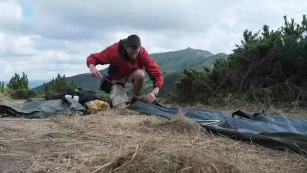 Turista viajante Define-se uma única tenda nas montanhas. Caminhadas. Turismo Solo. — Vídeo de Stock