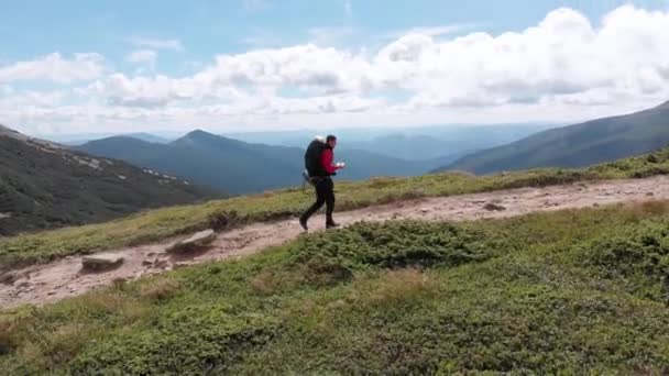 Luftaufnahme eines Reisefotografen mit Rucksack beim Bergsteigen — Stockvideo