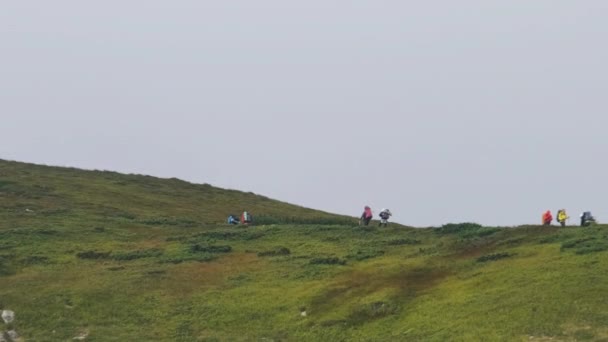 Eine Gruppe von Touristen mit Wanderrucksäcken besteigt die Bergkette. Blick in die Ferne — Stockvideo