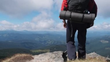 Dağın tepesinde sırt çantalı turist Yamacın yanında ellerini kaldırdı