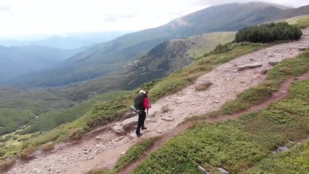 Luftaufnahme eines Reisefotografen mit Rucksack beim Bergsteigen — Stockvideo