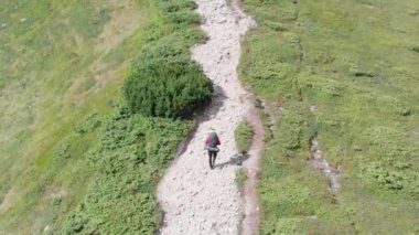 Sırt çantalı bir gezginin dağ yamacı boyunca tırmanış görüntüsü. Destansı Çekim