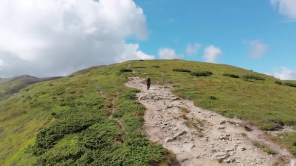 Vue aérienne d'un voyageur avec sac à dos grimpant le long du versant de la montagne. Tournage épique — Video