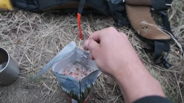 Reisende im Zelt, bereitet spezielle Mahlzeit im Paket mit kochendem Wasser zu — Stockvideo