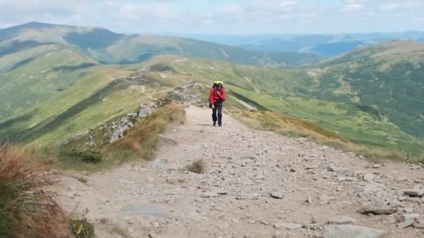 Turista con una mochila trepando a lo largo del sendero de montaña de piedra en la colina — Vídeo de stock