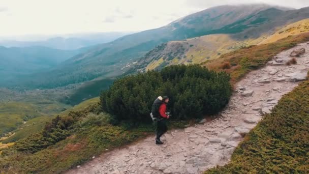 Sırt çantalı bir gezginin dağ yamacı boyunca tırmanış görüntüsü. Destansı Çekim — Stok video