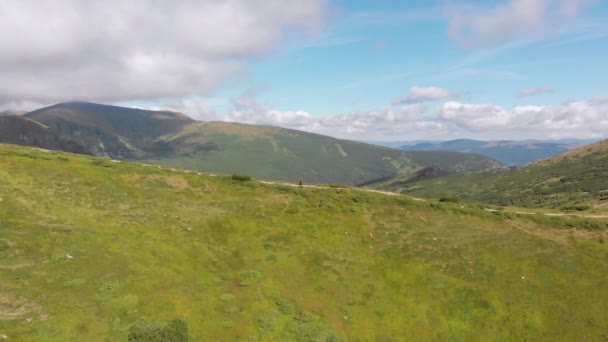 Vue aérienne d'un voyageur avec sac à dos grimpant le long du versant de la montagne. Tournage épique — Video