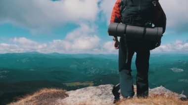 Dağın tepesinde sırt çantalı turist Yamacın yanında ellerini kaldırdı