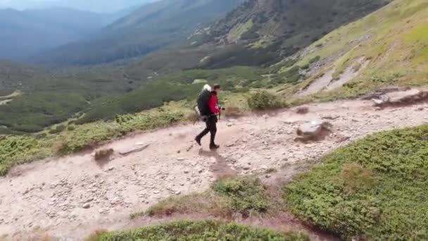 Luftaufnahme eines Reisefotografen mit Rucksack beim Bergsteigen — Stockvideo