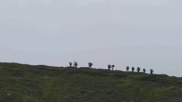 Grupo de Turistas con Mochilas Senderismo Escala la Cordillera. Vista lejana — Vídeos de Stock