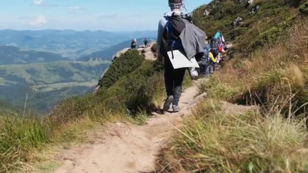 Grupp av turister och barn med ryggsäckar Gå ner på stenstig i berget — Stockvideo