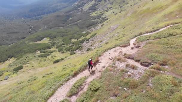 Veduta aerea di un viaggiatore con zaino Arrampicata lungo il pendio della montagna. Colpo epico — Video Stock