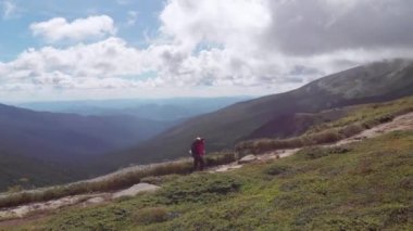 Sırt çantalı bir gezginin dağ sırasına tırmanışının hava görüntüsü. Destansı çekim