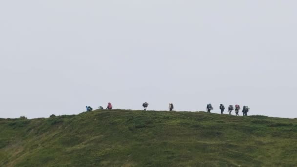 Grupo de Turistas con Mochilas Senderismo Escala la Cordillera. Vista lejana — Vídeos de Stock