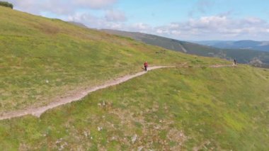 Sırt çantalı bir gezginin dağ yamacı boyunca tırmanış görüntüsü. Destansı Çekim