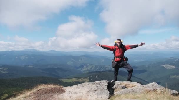 Dağın tepesinde sırt çantalı turist Yamacın yanında ellerini kaldırdı — Stok video