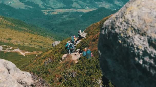 Skupina turistů a dětí s batohy jít dolů na kamenné stezce v horách — Stock video