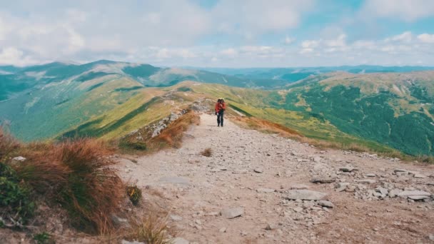 Turista con una mochila trepando a lo largo del sendero de montaña de piedra en la colina — Vídeos de Stock