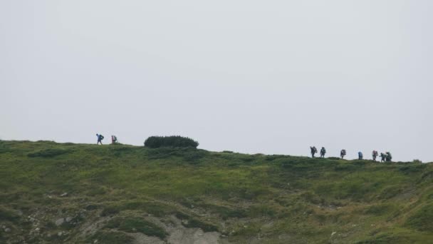 Grupp av turister med vandring ryggsäckar klättrar i Mountain Range. Utsikt över havet — Stockvideo