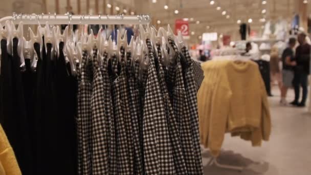 Tøj butik. Dame Tøj hænger på hængere inde i butikken. – Stock-video