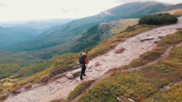 Luftaufnahme eines Reisefotografen mit Rucksack beim Bergsteigen — Stockvideo