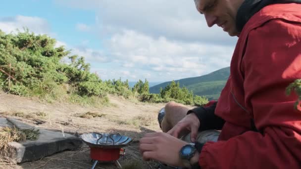 Τουριστικός ταξιδιώτης στα βουνά, προετοιμασία τσάι σε μια κουζίνα αερίου. Ατομικό ταξίδι — Αρχείο Βίντεο