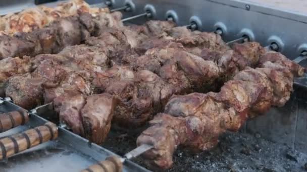 Shish Kebab sur brochettes est cuit sur le gril automatique au Street Food Festival. — Video