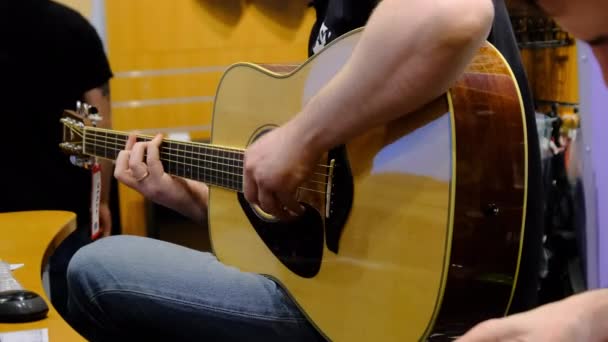 Bir Müzik Dükkanında Gitarist veya Satıcı Fiyat etiketli Akustik Gitar Çalıyor — Stok video
