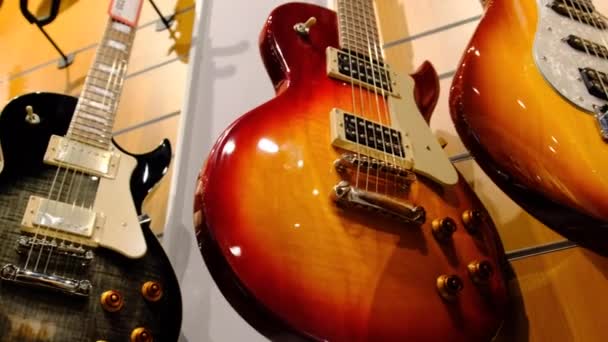 Магазин гитар. Много новых разноцветных электрогитар висят в музыкальном магазине — стоковое видео