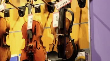 Bir müzik mağazasının duvarına etiketli bir dizi müzikal keman asıldı.