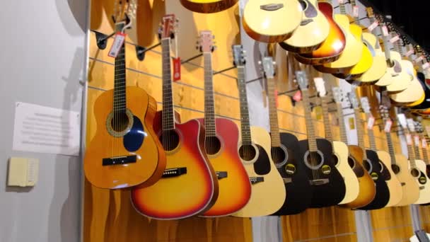 吉他手商店。音乐商店里挂着许多新的五彩缤纷的听觉吉他 — 图库视频影像