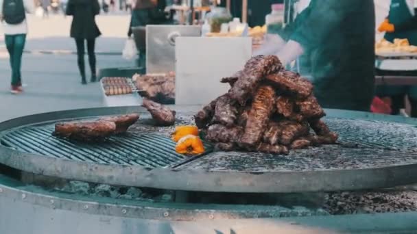 Большие куски говядины готовятся на гриле на улице на фестивале уличной еды — стоковое видео