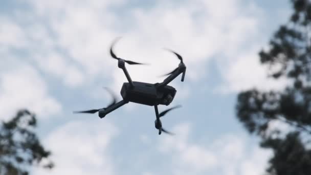 Drone cuelga en el aire contra el cielo azul, Vista desde abajo. Moción lenta — Vídeo de stock