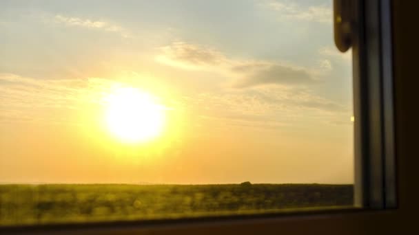 มุมมองพระอาทิตย์ตกผ่านหน้าต่าง ดวงอาทิตย์สีเหลืองสดใสเคลื่อนเหนือฮอไรซอน เวลา Lapse — วีดีโอสต็อก