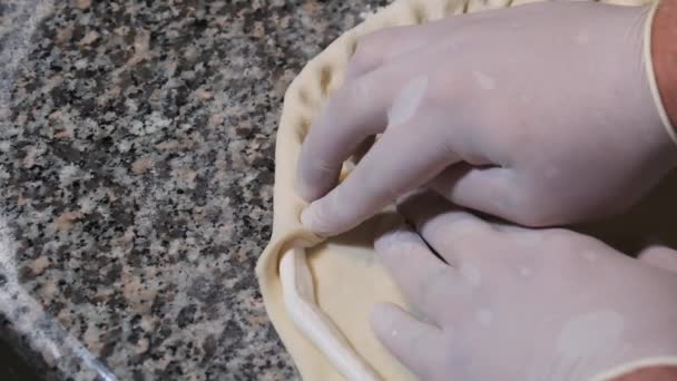 Chefs mains dans les gants Enveloppez la bordure du fromage dans la pâte à pizza crue. Mouvement lent — Video