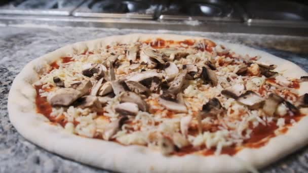 Шеф-повар восхитительно швыряет нарезанные грибы на пиццу. Slow Motion — стоковое видео