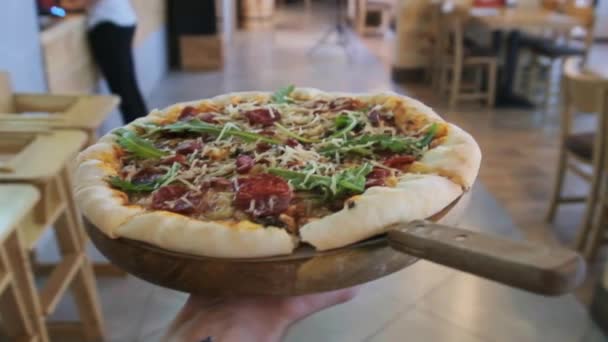 POV Waiter lleva la pizza en bandeja de madera a los clientes del restaurante. Moción lenta — Vídeos de Stock