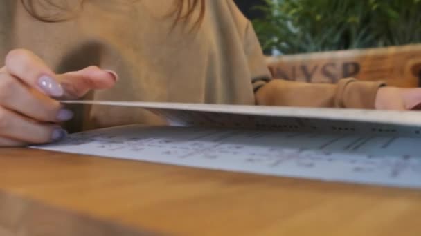 Back View of a Woman Reading a Menu in a Restaurant. Životní styl. — Stock video