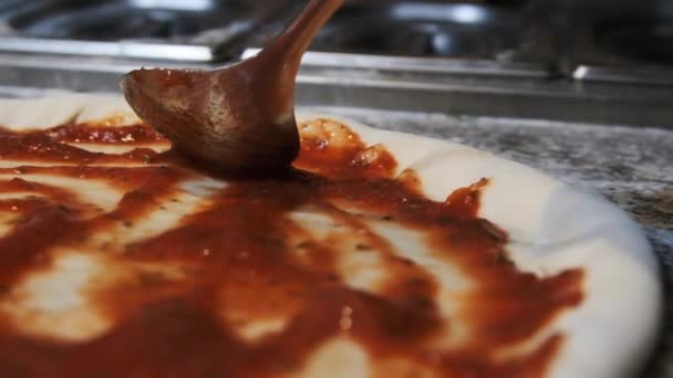 Chef Añadir salsa de tomate con cuchara y esparcir masa de pizza. Moción lenta — Vídeo de stock
