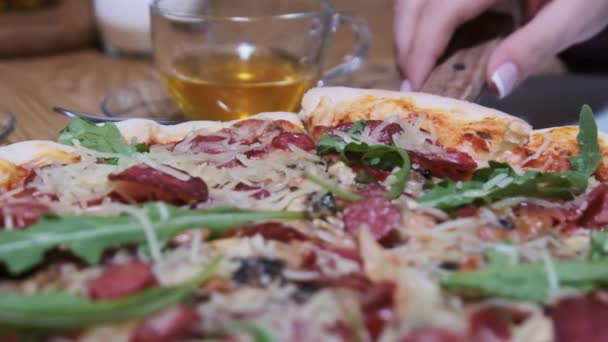 "Руки женщины берут кусочек пиццы из деревянной тарелки в ресторане". Slow Motion — стоковое видео