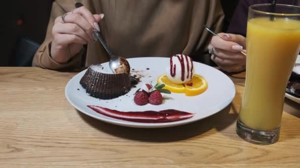 Přítelkyně jedí sladký dezert v restauraci. Čokoládový fondán. — Stock video